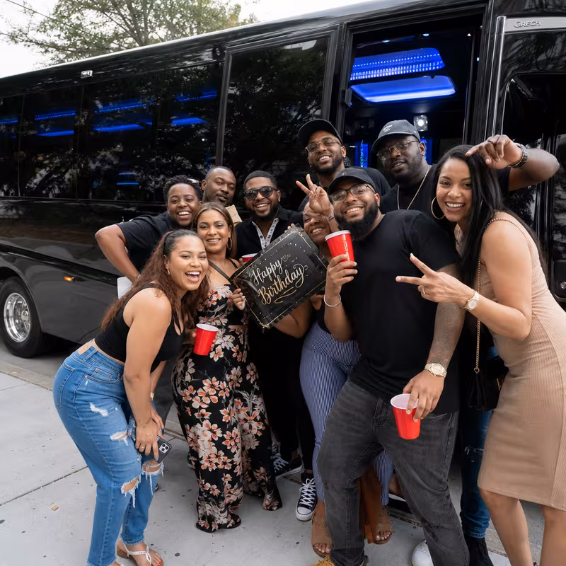 Group boarding a white charter bus for Birthday Transportation transportation in St Louis