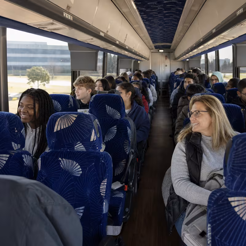 Group boarding a white charter bus for School Transportation transportation in St Louis
